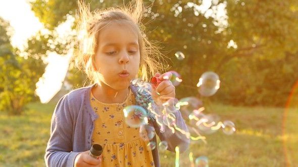 Girl Is Blowing Bubbles In The Sun