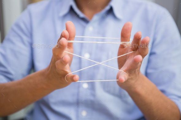 Close up mid section of man holding tangled string