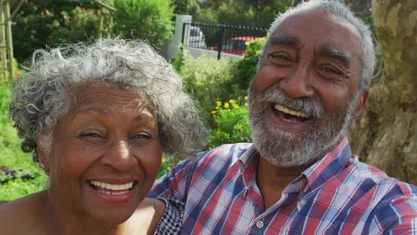 Animation of african american senior couple smiling at camera in garden alt
