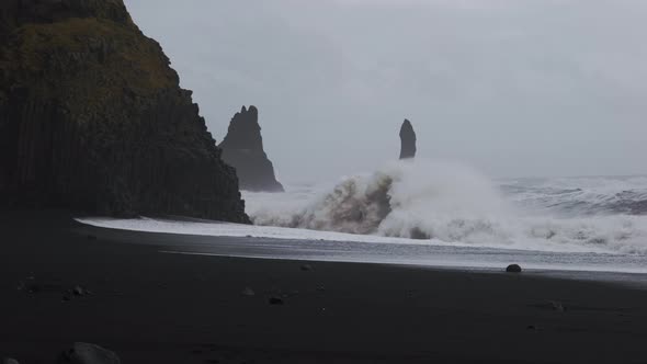 White Surf Crashing Into Rocks On Black Sand Beach alt