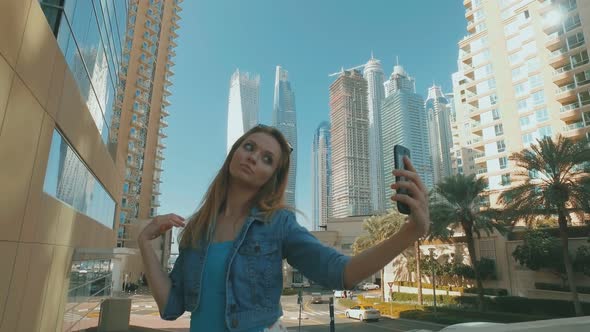 Playful Woman Is Taking Selfies By Mobile Phone, Outdoors in Dubai Marina in Sunny Day