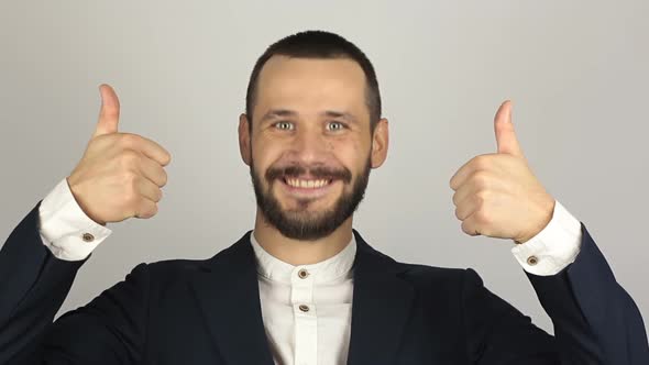 Young Handsome Businessman Is Smiling and Showing Thumb Up with Two Hands.