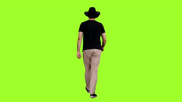 Walking Man in Black T-shirt and Cowboy Hat alt