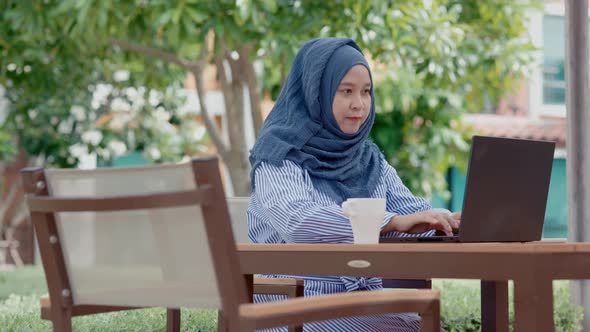 good looking Muslim women sitting outside working according to the slogan work form home