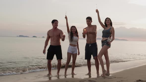 Fun dancing in the beach. Friends with sparklers dancing. Vacations concept