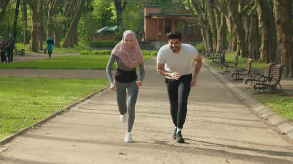 Positive Young People in Sport Clothes Running Together at Morning Park alt