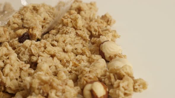 Pile of crunchy cereals close-up 4K 2160p 30fps UltraHD footage - Panning on muesli with whole hazel alt