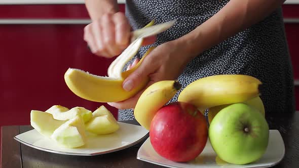 Young Housewife Peels Banana for Fresh Smoothies alt