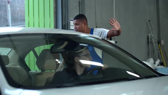 Mechanic Helps Driver To Leave the Garage alt