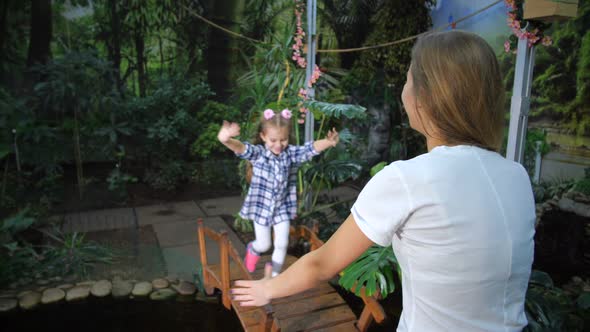 The Girl Runs to Meet Her Mother on the Bridge Jumps Into Her Arms Hugs and Rejoices Very Strongly alt