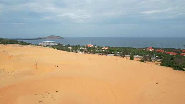 aerial of desert sand dunes near a highway road along the ocean in Mui Ne Vietnam alt