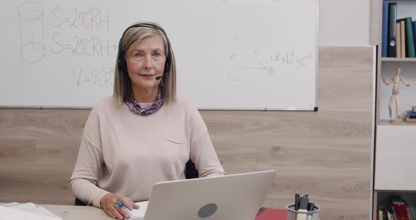 Portrait of Mature Woman in Wireless Headset with Microphone Looking To Camera alt