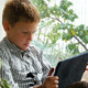 Boy Sitting By A Window Using His Tablet 1 - VideoHive Item for Sale