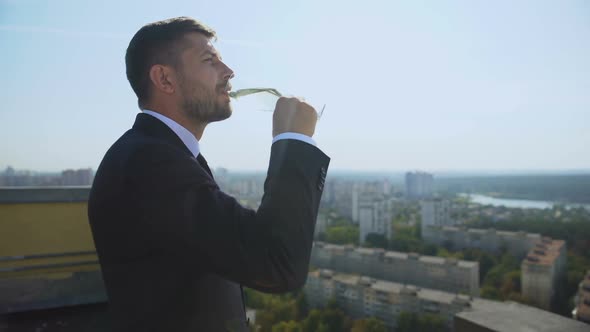 Male Manager Enjoying City View on Rooftop Drinking Champagne Glass, Celebration