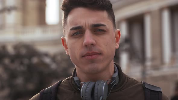 Portrait Closeup of European Handsome Guy 20s with Headphones Around Neck Relaxing After Walk in alt