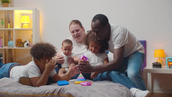 Young Multiethnic Family Spending Time Playing on Bed at Home alt