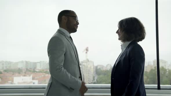 Smiling Colleagues Shaking Hands and Talking alt