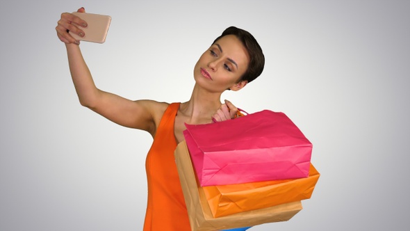 Attractive young woman holding different blank shopping bags alt