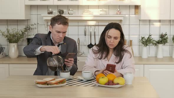Couple Drinking Coffee While Using Smartphones alt