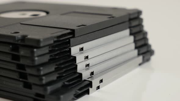 Classic magnetic  floppy disc media on white slow tilt 4K 2160p 30fps UHD footage - Black data stora alt