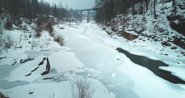 Winter Forest Frozen River is Covered with Snow Aerial View alt