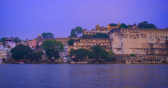 Udaipur City at Sunset: Houses, Ghat and City Palace on Lake Pichola. Rajasthan, India. Horizontal alt