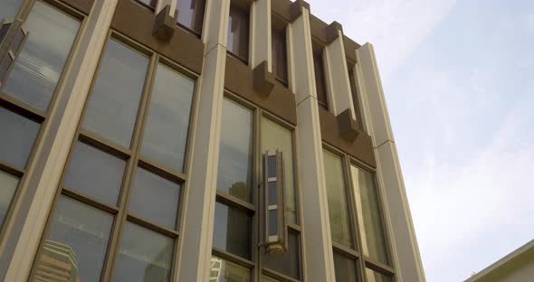 Downtown city building with large windows and pan over to American flag in the courtyard alt