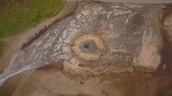 A drone footage of a geyser erupting from above in Iceland alt