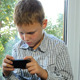 Boy Sitting By A Window Using His Smartphone - VideoHive Item for Sale