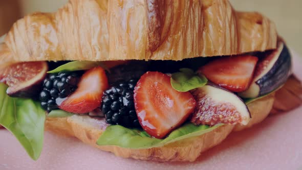 Beautiful Crispy Golden Berry Croissant with Strawberries Blackberries and Basil on Pink Plate alt
