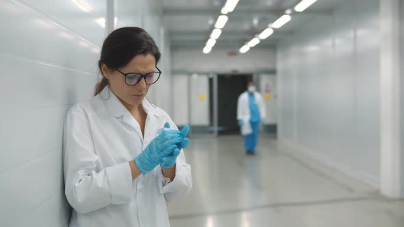 Sick Female Doctor Coughing in Safety Mask Standing in Hospital Hallway alt
