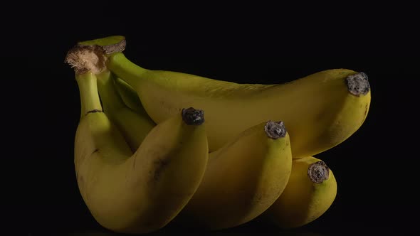 Closeup Shot of Wet Rotating Bananas with a Black Background