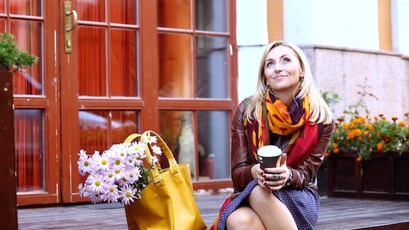 Woman Waiting On The Street Drinking Coffee