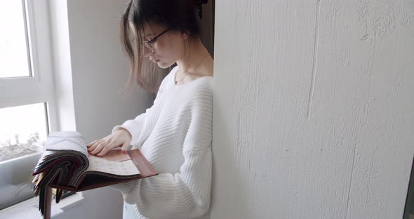 Young Women in the Store Who Choose Fabrics From the Color Palette in Showroom alt