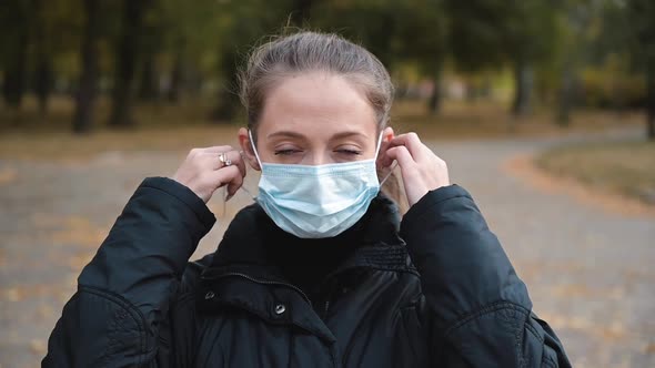 Young Woman Takes Off Medical Mask