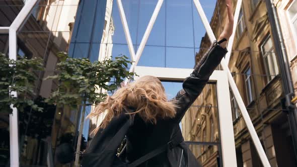 Cheerful Caucasian Girl with Long Hair in Stylish Glasses Happy Walking Down the City Street alt