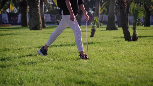 Sporty Woman Standing on the Lawn and Doing Exercises alt
