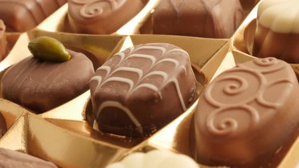 Gift decorative box of chocolates many different candies slow tilt 4K 2160p 30fps UltraHD footage -  alt