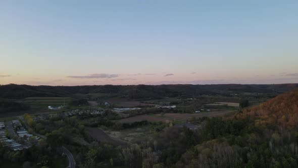 Aerial view of valley and rural countryside at duck. Small neighborhoods and farm fields also seen.