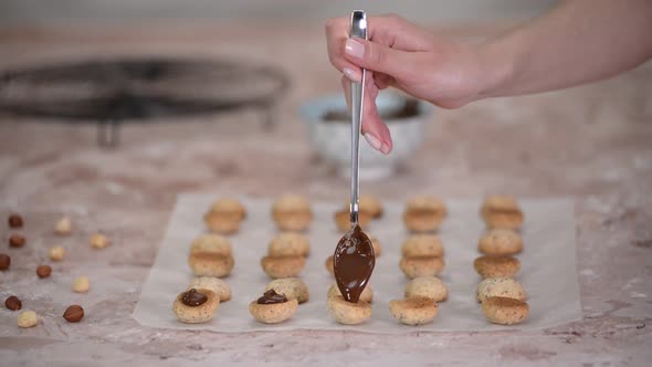 Pouring dark melted chocolate over of homemade cookies.
