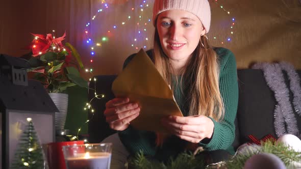 Happy Young Woman Reading Christmas Greeting Card alt