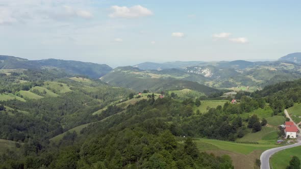 Drone Flight in the Mountains Small House Surrounded By Fields alt