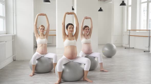Group of Women in Sportswear Doing Pregnant Exercises Sitting on Fitness Sword