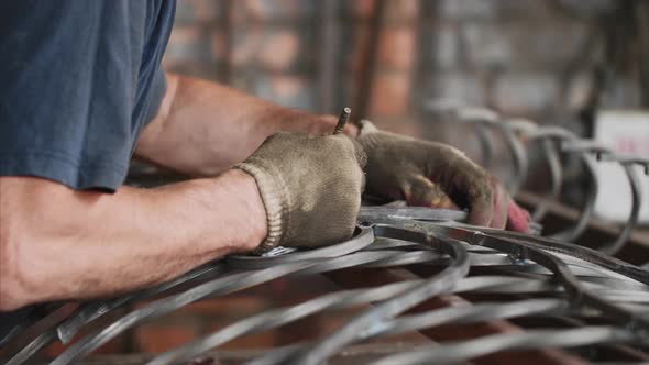 Locksmith Makes Notes with Pencil on Metal Bar Puts Detail To Fence in Workshop. alt