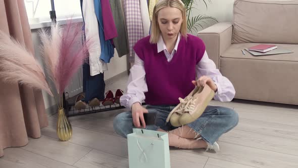 A Woman Takes Photos of Pink Fashion Sneakers with a Smartphone