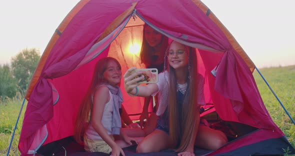 Four Teenage Girls Making Selfie in Camp Tent in Mountains alt