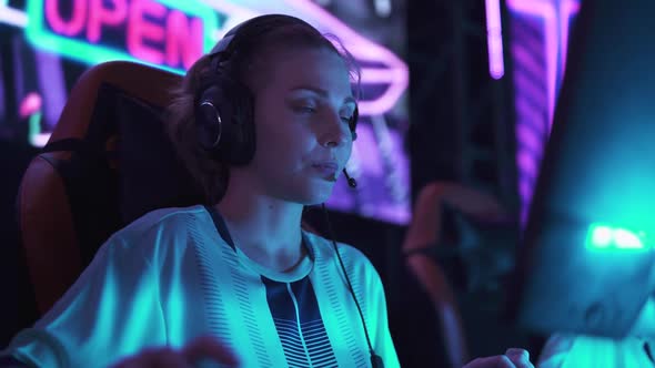 An Emotional Female Gamer in Headphones Plays a Video Game Cyber Sportsman Shouts and Communicates alt