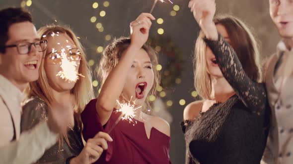 Asian Girl and Group Young College Student Friends Lit Light Sparkler in Hand Fireworks Sing and alt