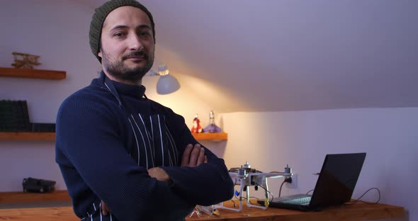 A Mechanic with Arms Crossed on His Chest Smiles Against the Backdrop of a Home Interior with a alt