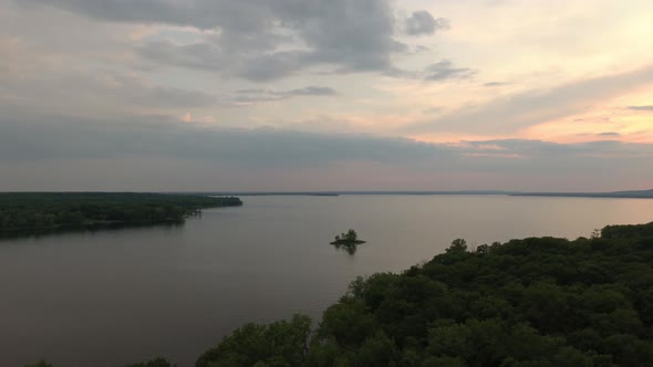 Nature coastal drone shot of bay and land with small hills in the distance alt